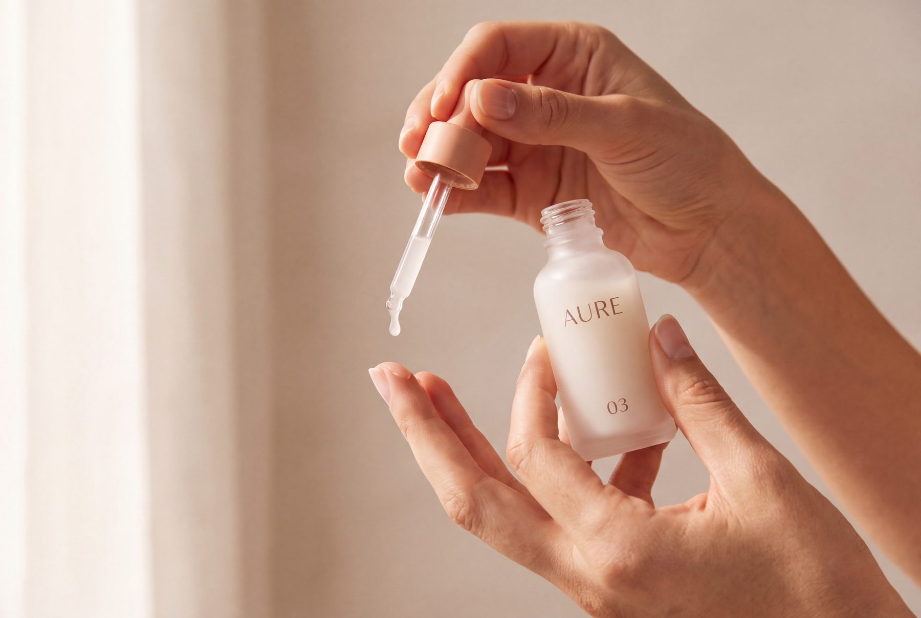 A drop of Clear Serum falling onto fingertips